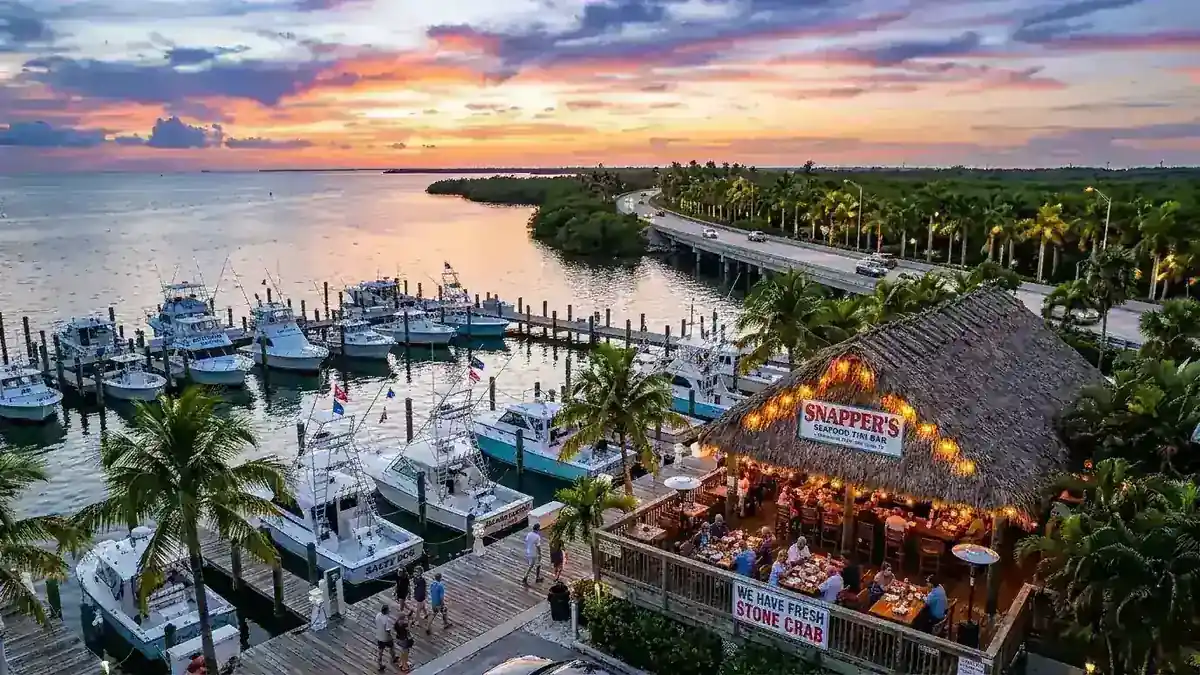 Panoramic view of Key Largo waterfront seafood tiki restaurant at sunset with charter boats in Florida Keys